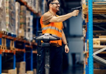 Lagermitarbeiter steht im Lager und scannt Ware ein